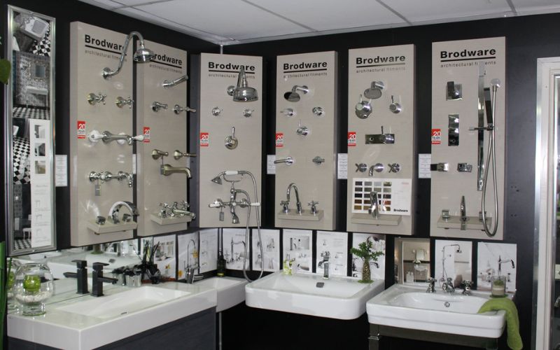 Showroom thiết bị vệ sinh với kệ trưng bày đính tường kèm tên thương hiệu