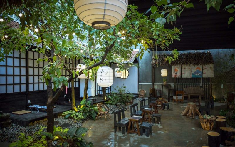 Quán cafe sân vườn với bàn ghế thấp, đèn lồng thuộc văn hóa Nhật Bản