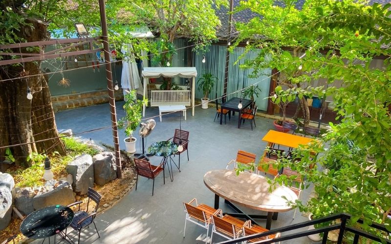 Quán cafe sân vườn với nội thất bằng gỗ, rợp bóng cây xanh