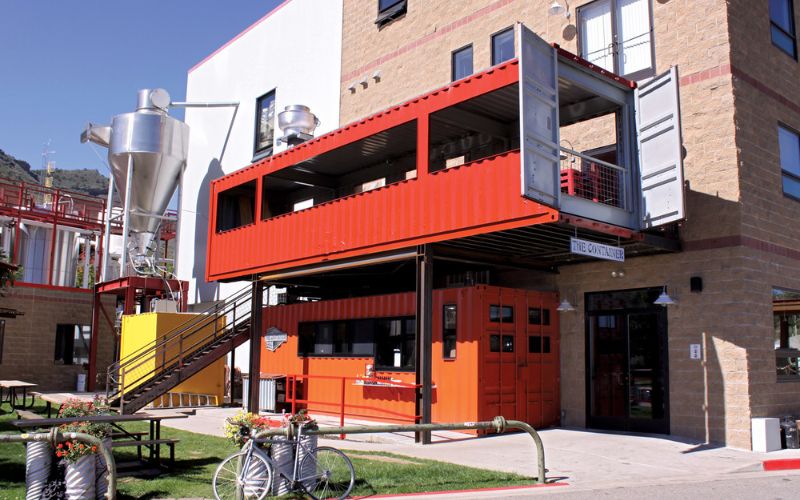 Quán trà sữa container hai tầng phong cách tối giản với màu cam nổi bật